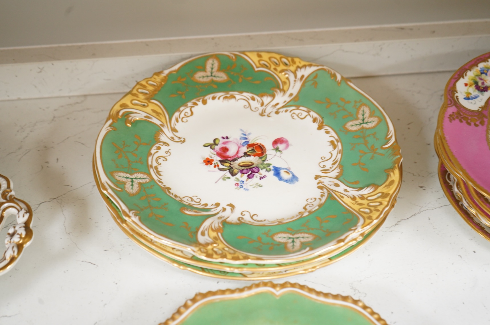 A collection of 19th century English dessert wares to include a pair of Flight, Barr and Barr ‘fantastic birds’ green ground dessert plates, various Ridgway dessert plates, five Minton botanical plates with tooled gilt b